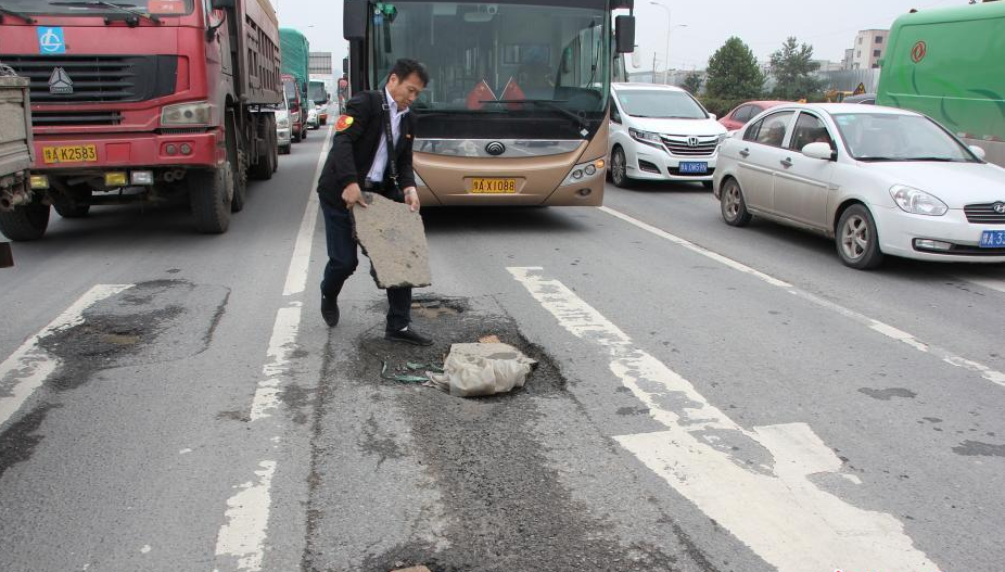 公交车司机自备一箱砖块 一路行驶一路填坑