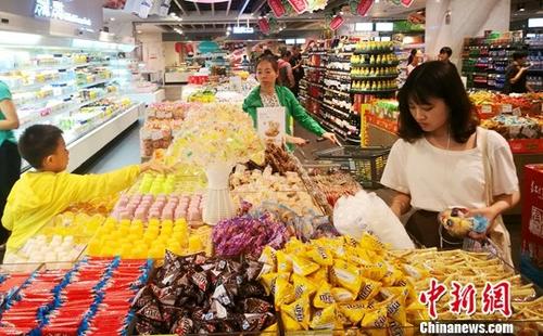 7月17日，中国国家统计局发布的数据显示，1至6月中国社会消费品零售总额172369亿元人民币，同比名义增长10.4%，增速比一季度加快0.4个百分点。图为成都某超市内正在选购糖果的民众。 记者 刘忠俊 摄