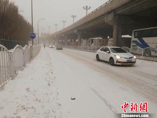 路上车辆开灯缓行。　戚亚平 摄