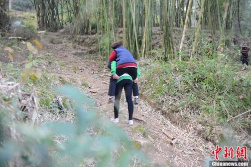 李小燕背着奶奶外出。余剑 摄 李小燕背着奶奶外出。余剑 摄