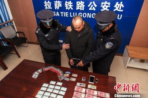 资料图:一犯罪嫌疑人对拉萨铁路警方查获的火车票进行指认。 胡传鑫 摄 资料图:一犯罪嫌疑人对拉萨铁路警方查获的火车票进行指认。 胡传鑫 摄