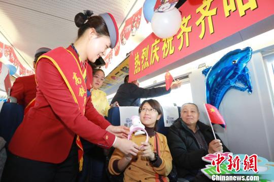图为高铁内列车员为乘客发放纪念品。(张学鹏摄) 图为高铁内列车员为乘客发放纪念品。(张学鹏摄)